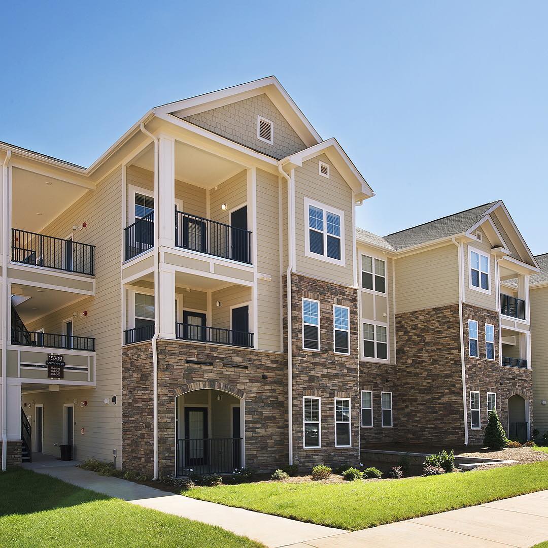 Front view of a multi-level apartment complex with balcony patios.