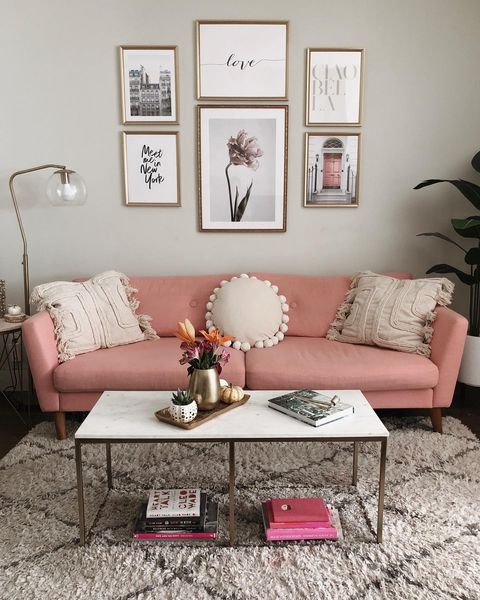 Interior view of an apartment with a pink couch and marble coffee table.
