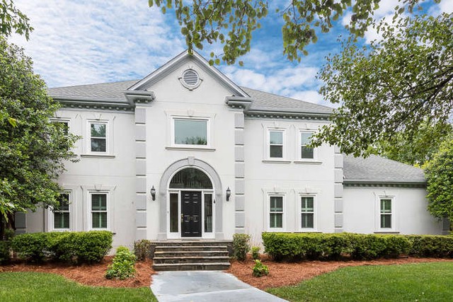 Front view of a large home with a manicured yard.