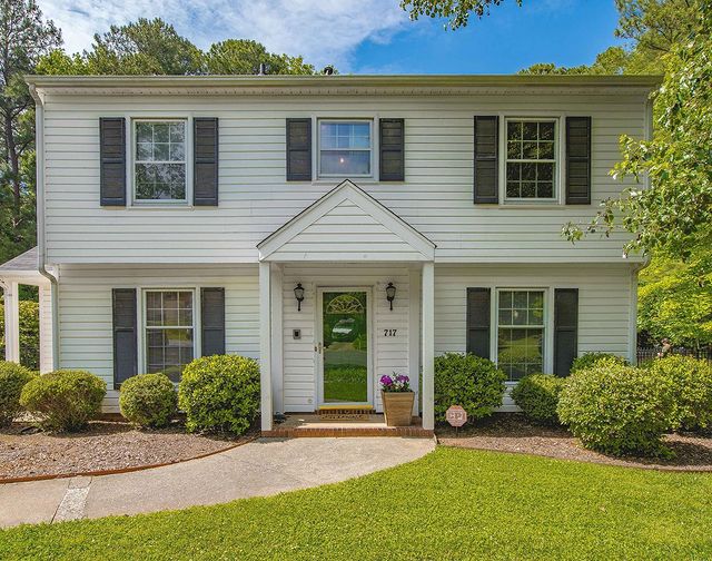 Front view of a two level home with a walking path leading to the front door. 