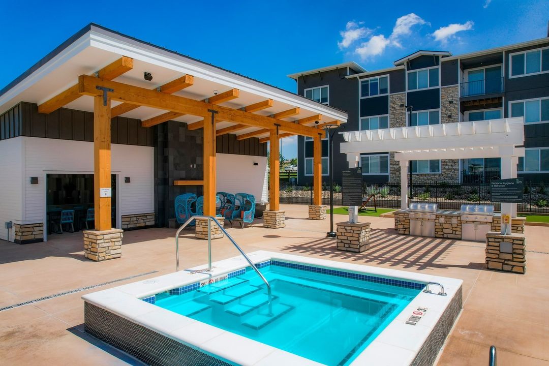 Outdoor pool and grill area at an apartment complex. Photo by Instagram user @enovaapartments.