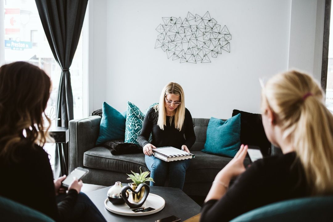 Two people sitting down with the property manager reviewing the lease. Photo by Instagram user @flexproperty.