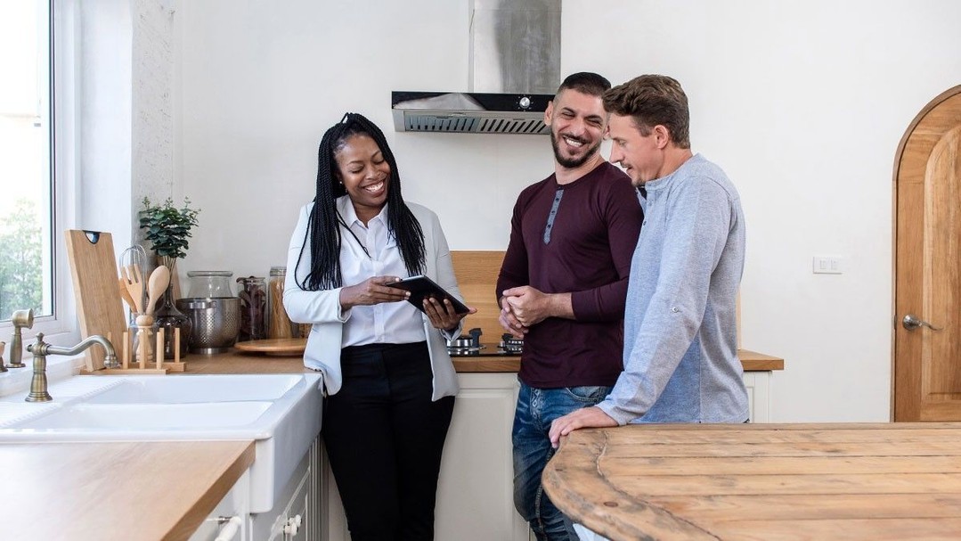 Three people in the kitchen of an apartment having a discussion over a tablet. Photo by Instagram user @edwardslisky