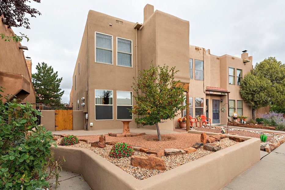 Adobe-style Santa Fe townhome with large windows. Photo by Instagram user @sellingsantafe.