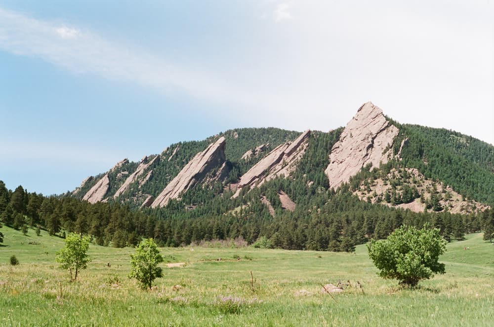 Mountains behind a green field in Boulder, Colorado