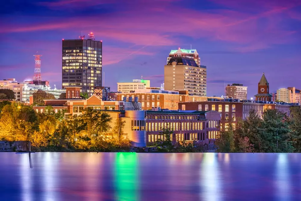 Image of downtown Manchester, NH skyline at twilight. Featured Image for Best Neighborhoods in Manchester for Singles & Young Professionals.