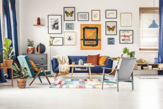 Photo of a bright living room with a gallery wall featuring different types of artwork. Featured Image for How to Create a Gallery Wall.