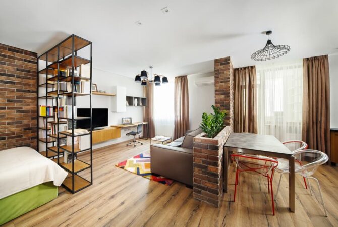 A studio apartment is divided into zones for sleeping, dining, entertainment, and storage.