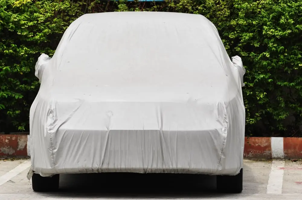 Small car in outdoor parking space with cover for long-term vehicle storage