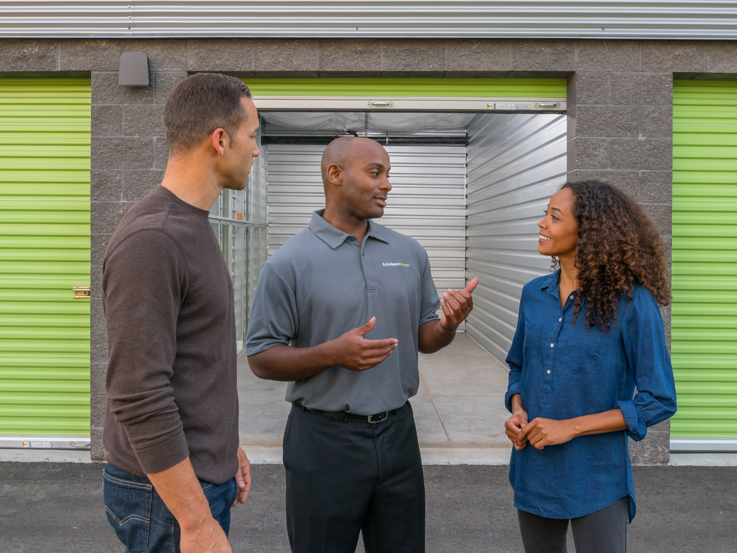 An Extra Space Storage staff member is seen talking to two customers.