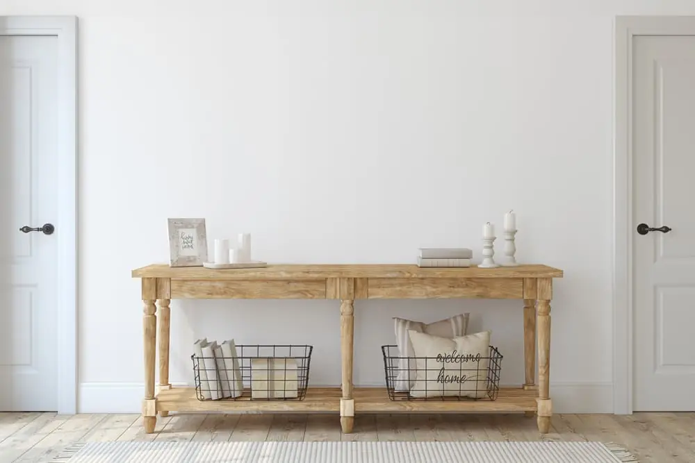 Photo shows an example of a console table with baskets placed underneath on the shelves.
