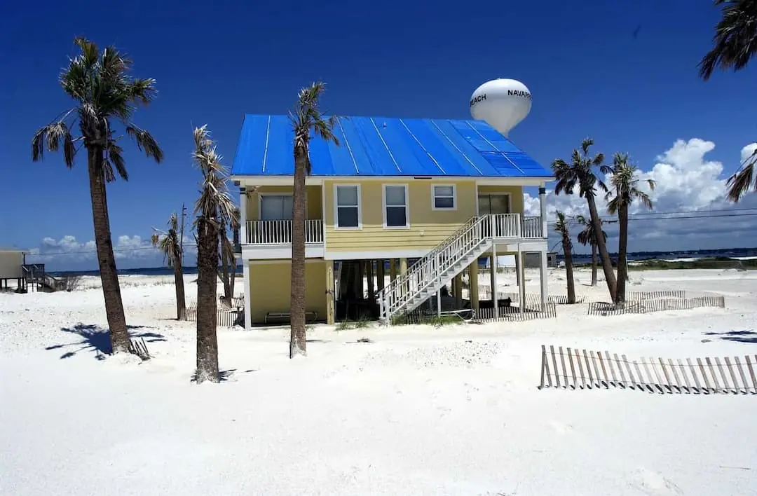 Yellow house surrounded by palm trees on a beach