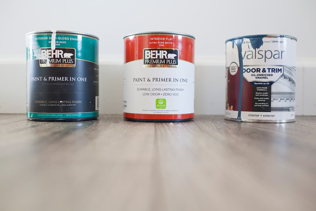 Three cans of house paint on the floor