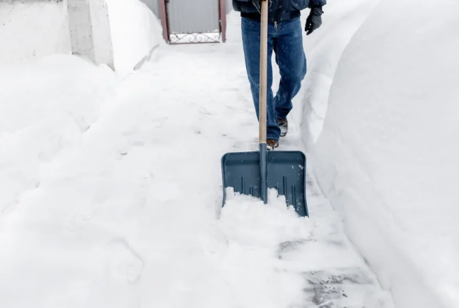 A person shoveling a driveway