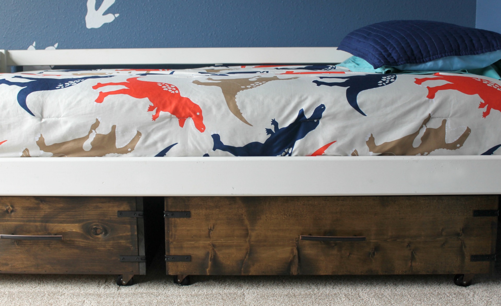 Drawers for storage are tucked under a bed.