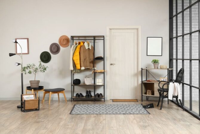 A clean and organized winter entryway with shelves and a rug.
